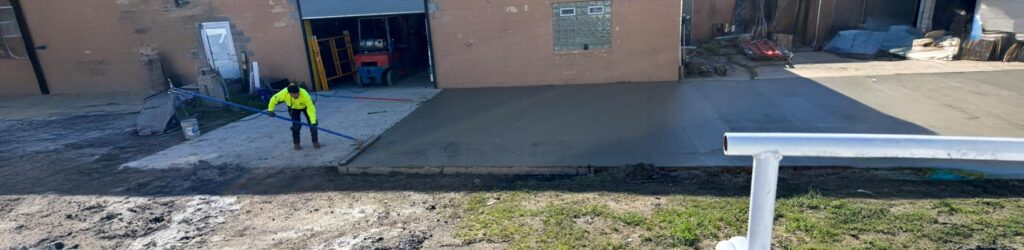 Professional concrete contractors smoothing a fresh commercial concrete pour
