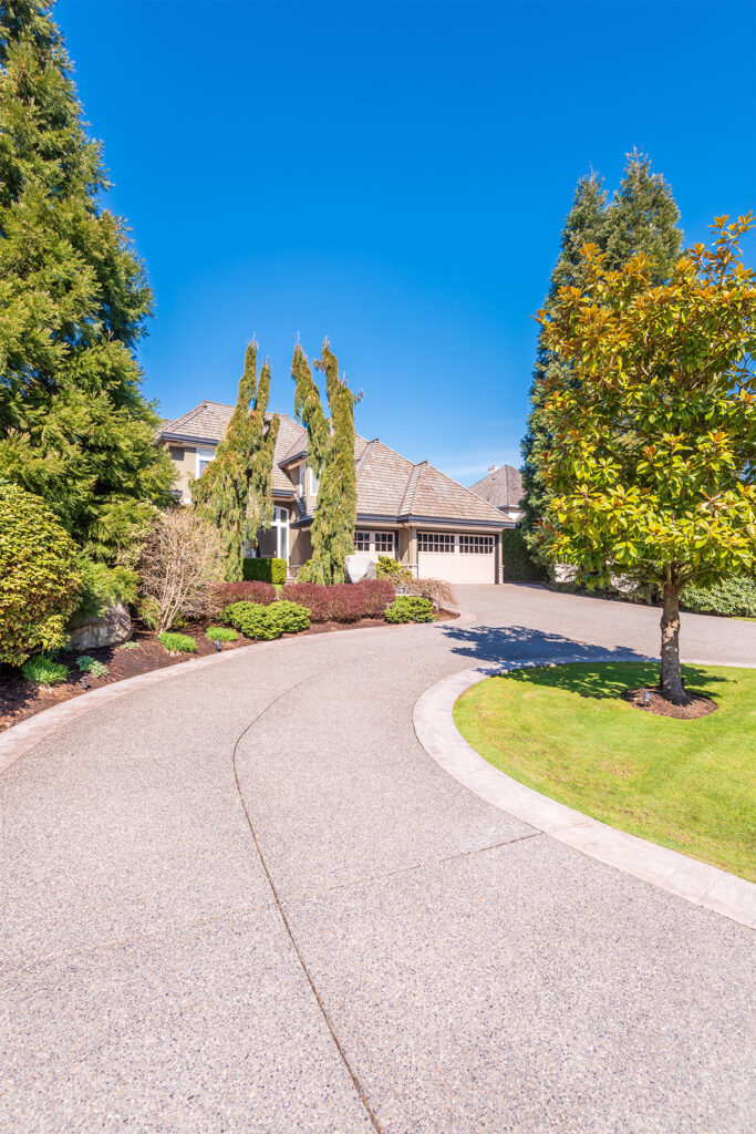 Residential exposed aggregate concrete driveway in a Bloomfield Hills neighborhood.